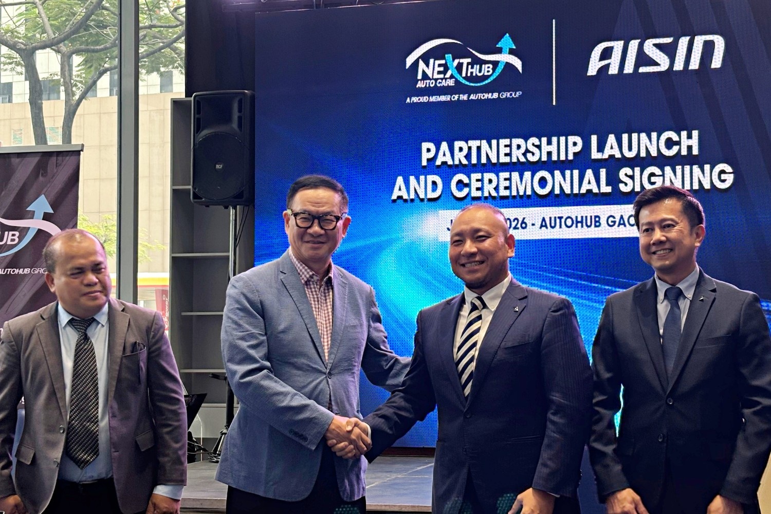 AISIN and NEXTHUB officials make the partnership official with MOA signing and a handshake